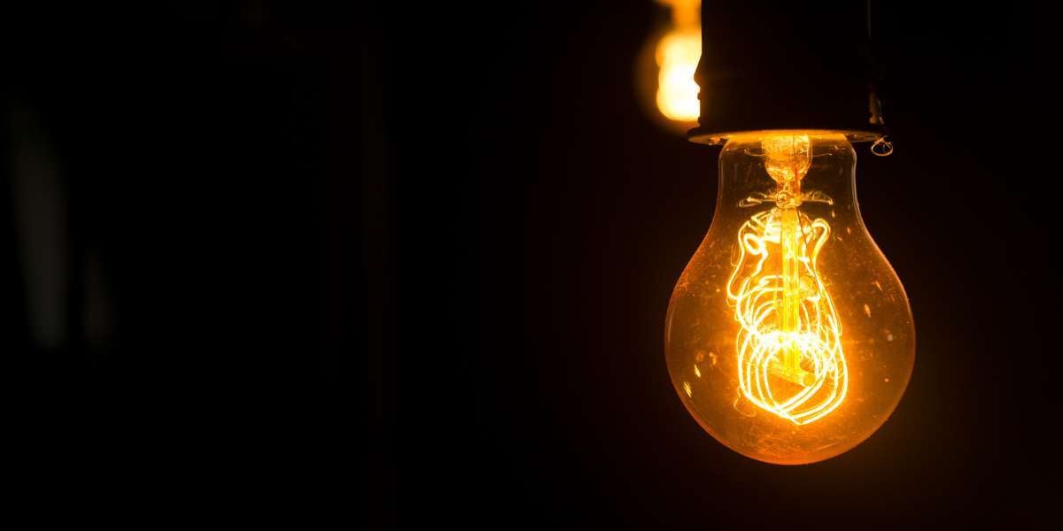 Close-up of a glowing filament lightbulb against a dark background