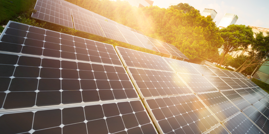 Solar panels generating renewable energy with sunlight over a modern urban landscape